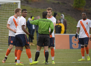 An official issues a yellow card while speaking with Pasanen.