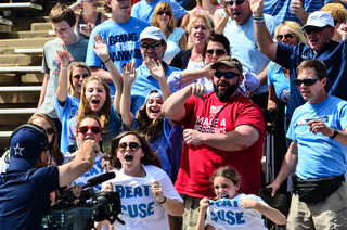 A camera man instructs a group of UNC fans to get rowdy.