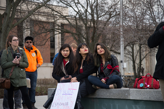 Three SU students sit together. All three spoke at the rally, calling for unity against aggressive immigration enforcement tactics.