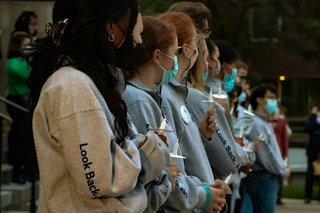 Remembrance Scholars watch a musical performance before the candle lighting. 