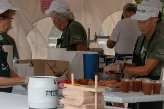 Beaver Lake Nature Center workers and volunteers push to put out hundreds of homemade  cinnamon sugar donuts and cups of apple cider for purchase by the public for $1 each. Lines for these donuts stood 15-20 people back, but moved quickly due to the efficiency of the workers. 